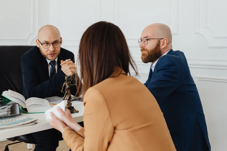 Equipe de advogados reunida em discussão de trabalho num escritório moderno